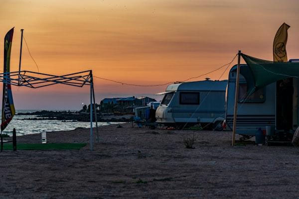 stylish caravan awning scene with compact BBQ station, folding prep table, soft LED lighting, and organized cooking tools
