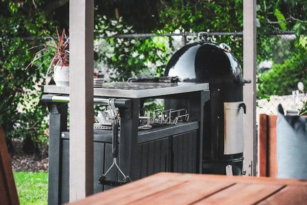 compact caravan campsite with slide-out BBQ, timber prep board, warm awning lights, and Australian bush backdrop